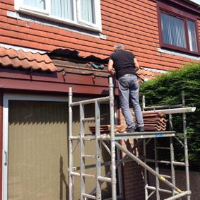 one of our team on scaffolding fixing a roof